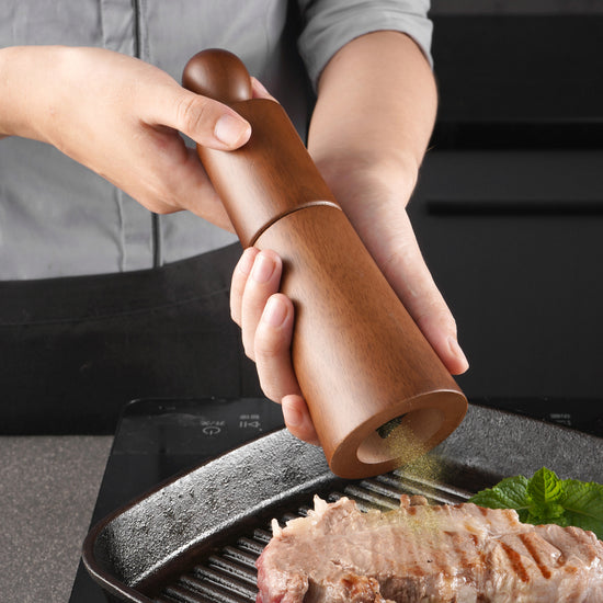 Professional manual pepper grinder with adjustable ceramic core and artisan wooden spice muller for gourmet kitchens.