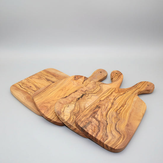 Irregular solid olive wood cutting board by WoodyKitchenware, Mediterranean Shield design, natural wood grain, 30x15cm kitchen accessory.