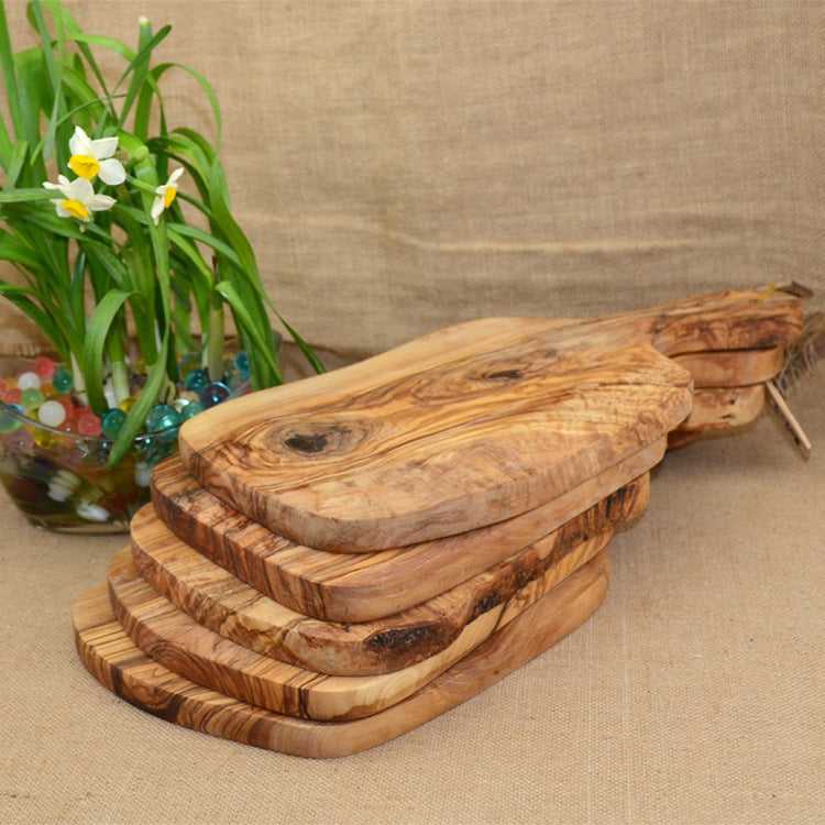 Irregular solid olive wood cutting board by WoodyKitchenware, featuring natural Mediterranean shield design and smooth finish.