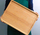 Rectangular bamboo wooden dinner tray by WoodyKitchenware, showing a natural grain finish and sturdy handles for household use.