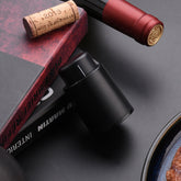 Black electric wine opener set by WoodyKitchenware with automatic corkscrew, foil cutter, and can opener on a sleek countertop.