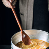 Long wooden cooking spoon by WoodyKitchenware, ideal for deep pots and stirring, with a smooth brown finish.
