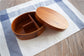 Round brown wooden bento box by WoodyKitchenware, traditional Japanese lunch box made of smooth polished wood.