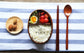 Round brown wooden bento box by WoodyKitchenware, traditional Japanese lunch box with smooth wood finish and compact design.