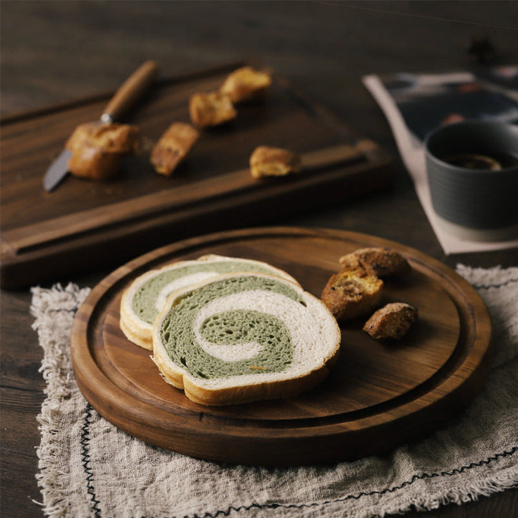 Round black walnut wood cutting board by WoodyKitchenware, featuring a smooth surface perfect for kitchen prep and serving.